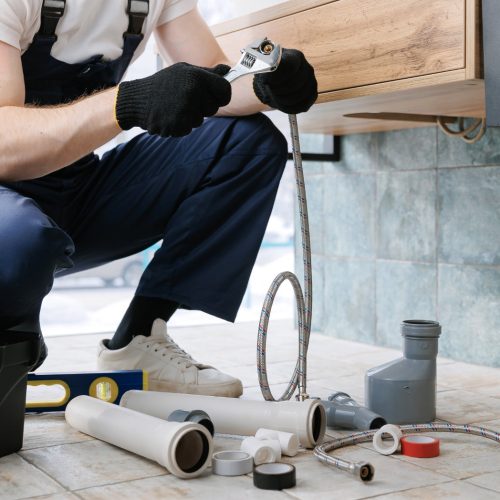 Plumber,Man,Fix,Repair,Service,Wraps,Fluoroplastic,Sealing,Material,Tape Plumber man fix repair service wraps fluoroplastic sealing material tape around faucet hose. Concept install plumbing in bathroom.